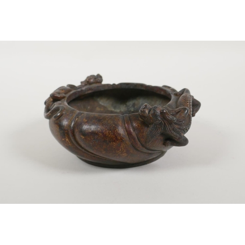 40 - A Chinese gilt bronze censer of lobed form, with raised twin dragon decoration, impressed mark to ba... 