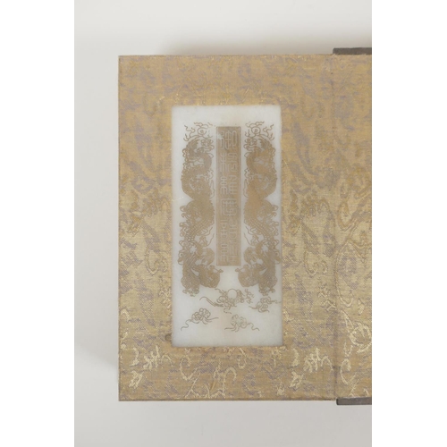 50 - A Chinese silk and wood bound book containing white jade tablets with chased and gilt inscriptions, ... 