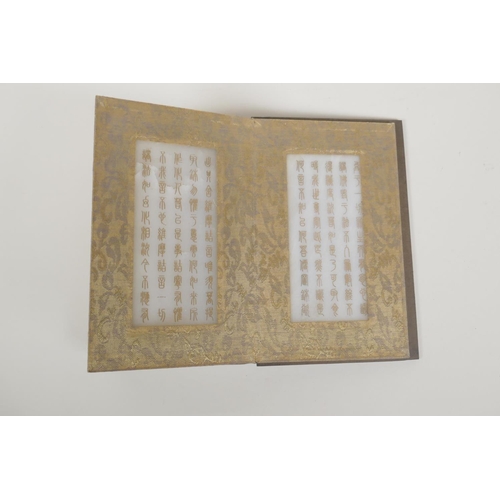 50 - A Chinese silk and wood bound book containing white jade tablets with chased and gilt inscriptions, ... 