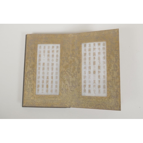 50 - A Chinese silk and wood bound book containing white jade tablets with chased and gilt inscriptions, ... 