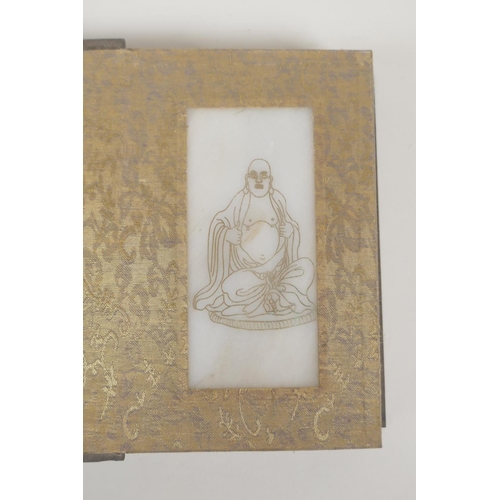 50 - A Chinese silk and wood bound book containing white jade tablets with chased and gilt inscriptions, ... 