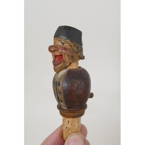 51 - A set of four carved and painted Black Forest figural caricature bottle stoppers/pourers, in a wall ... 