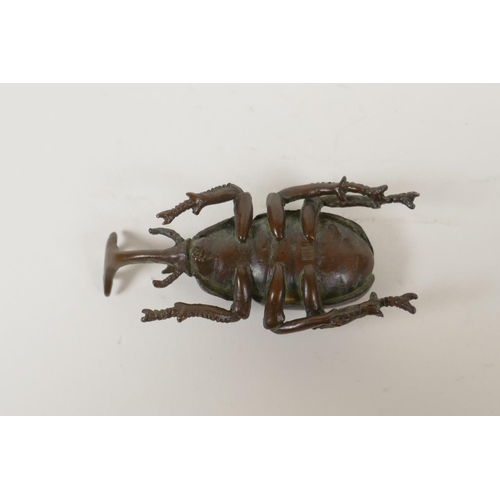 8 - A Japanese bronze okimono in the form of a horned beetle, impressed mark to base, 3