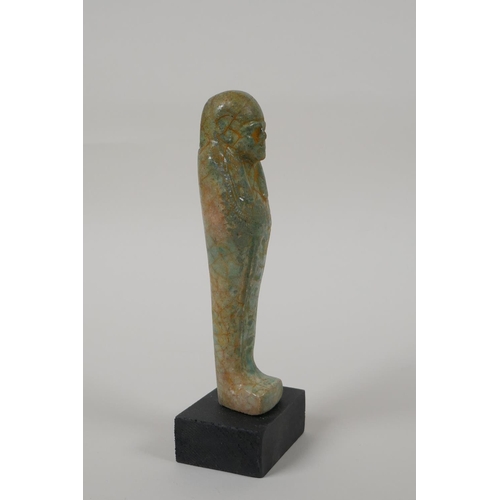 14 - An Egyptian turquoise glazed faience shabti, mounted on a display base, 6