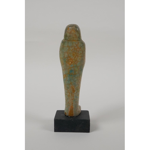 14 - An Egyptian turquoise glazed faience shabti, mounted on a display base, 6