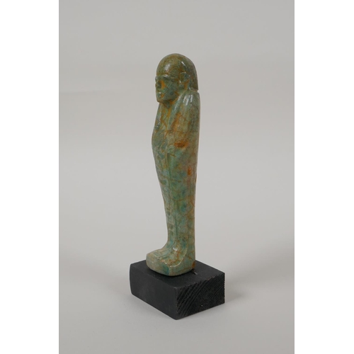 14 - An Egyptian turquoise glazed faience shabti, mounted on a display base, 6