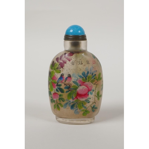 18 - A Chinese reverse decorated glass snuff bottle depicting birds amongst branches bearing fruit and bl... 