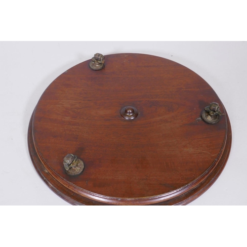 35 - A mahogany revolving table stand, fitted with three brass and leather castors, 15