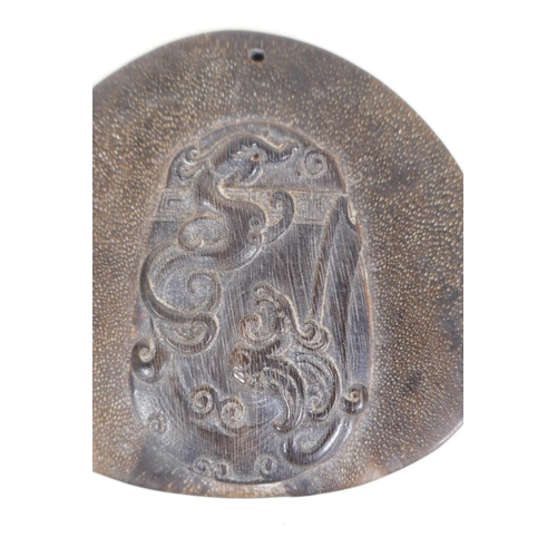 5 - A Chinese carved hoof pendant with stylised dragon decoration and another similar, 2½