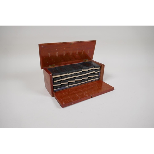 54 - An antique bone and ebony domino set with brass pins, in a fitted box