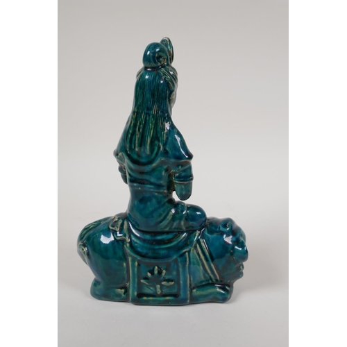 15 - An emerald glazed porcelain Quanyin seated on a kylin, 8½