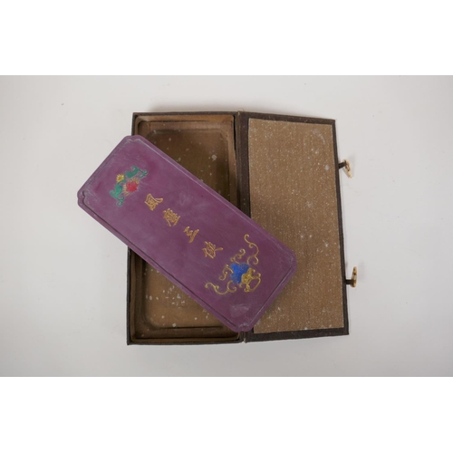 60 - A Chinese mauve ground ink stone decorated with farming figures highlighted in gilt, boxed, 4½... 