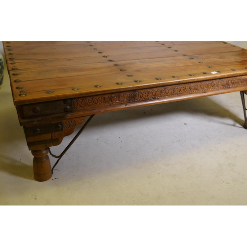 1198 - A large Indian coffee table, with iron mounts and brackets and carved frieze, 45