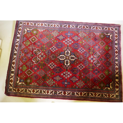 1214 - An oriental Maymeh wool carpet with all over geometric designs and central medallion on a red field,... 