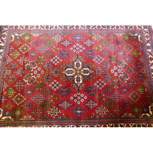 1214 - An oriental Maymeh wool carpet with all over geometric designs and central medallion on a red field,... 