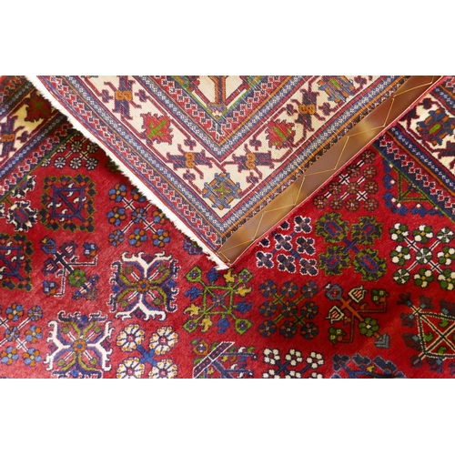 1214 - An oriental Maymeh wool carpet with all over geometric designs and central medallion on a red field,... 