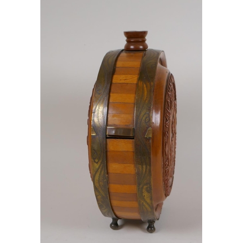 23 - A brass bound carved wood wine flask with coat of arms and fruiting vine decoration, 8½