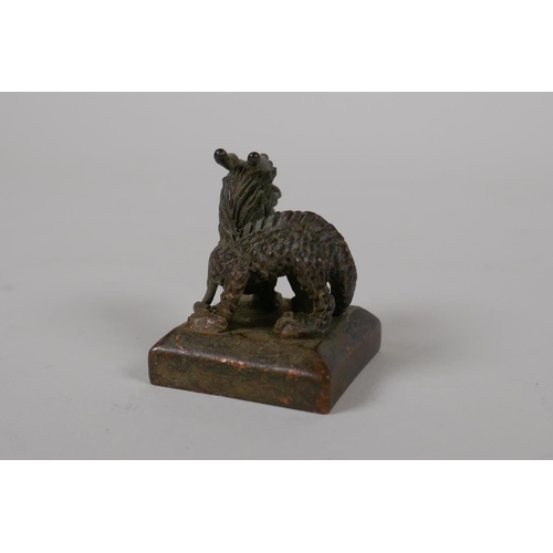 55 - A Chinese archaic style bronze seal with a dragon knop, 1½