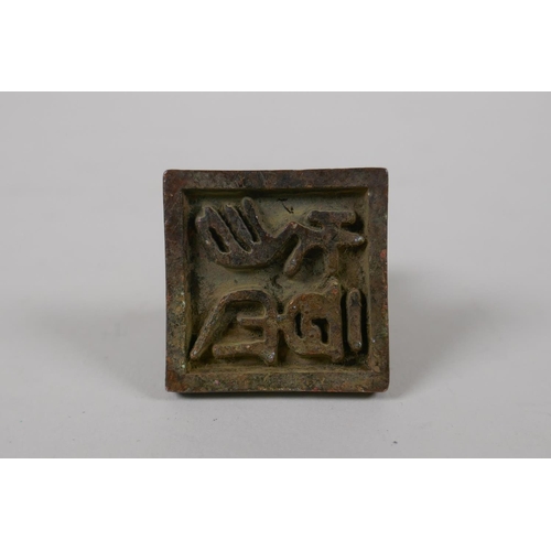 55 - A Chinese archaic style bronze seal with a dragon knop, 1½