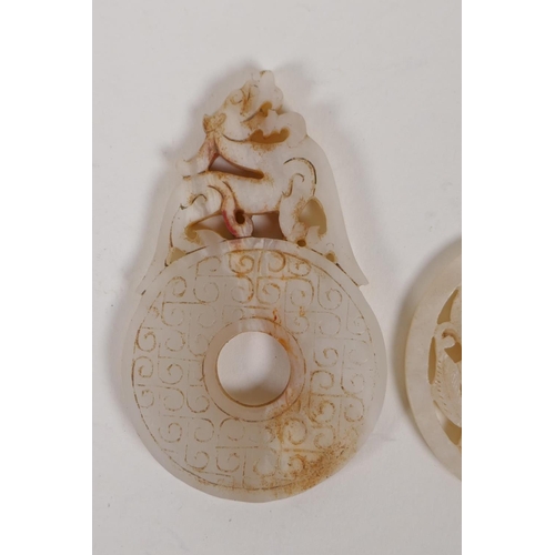 60 - A Chinese carved and pierced white jade pendant with dragon decoration, and another in the form of a... 