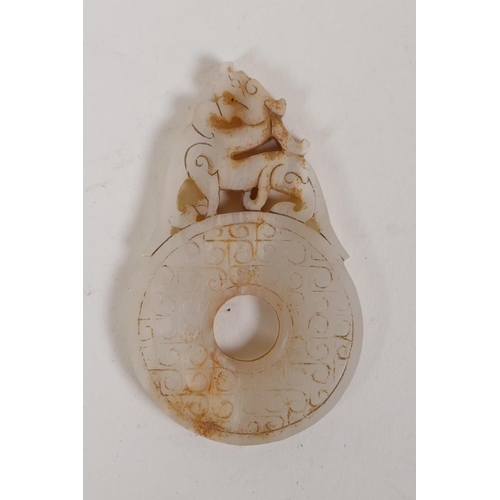 60 - A Chinese carved and pierced white jade pendant with dragon decoration, and another in the form of a... 