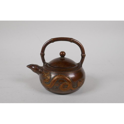 88 - A Chinese bronze teapot of squat form with bamboo style handle and spout, and dragon decoration, imp... 