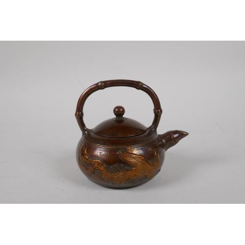 88 - A Chinese bronze teapot of squat form with bamboo style handle and spout, and dragon decoration, imp... 