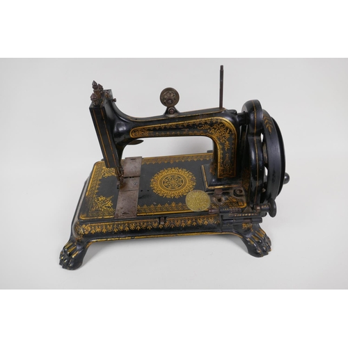 1 - A small antique sewing machine on cast iron base with paw feet and gilt decoration (probably Jones),... 