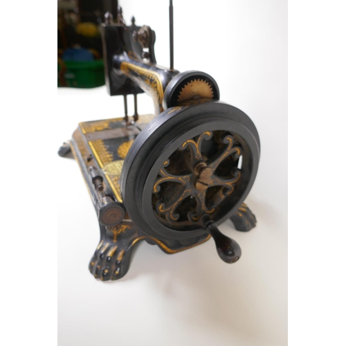 1 - A small antique sewing machine on cast iron base with paw feet and gilt decoration (probably Jones),... 