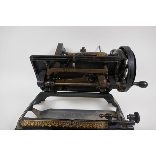 1 - A small antique sewing machine on cast iron base with paw feet and gilt decoration (probably Jones),... 