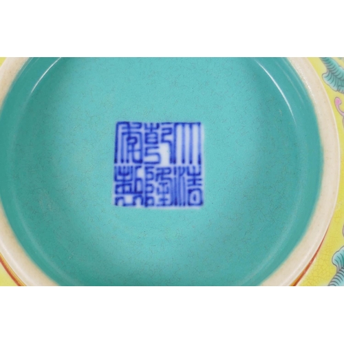 30 - An enamelled porcelain rice bowl with famille rose decoration on a yellow ground and a turquoise int... 