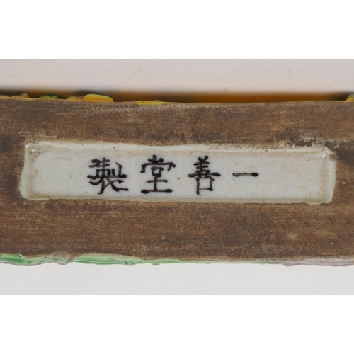 47 - A Chinese porcelain brush rest embossed with many figures, with 3 character mark to base