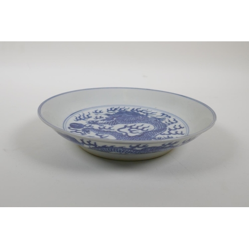 50 - A blue and white porcelain dish decorated with a dragon chasing the flaming pearl, Qianlong seal mar... 