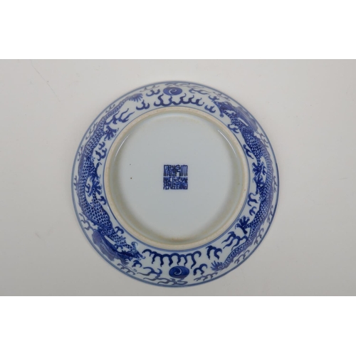 50 - A blue and white porcelain dish decorated with a dragon chasing the flaming pearl, Qianlong seal mar... 