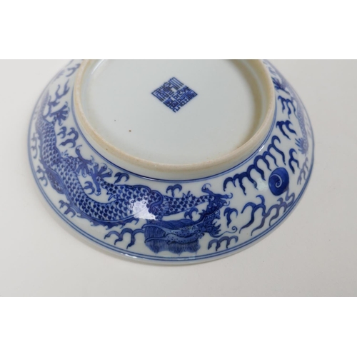 50 - A blue and white porcelain dish decorated with a dragon chasing the flaming pearl, Qianlong seal mar... 