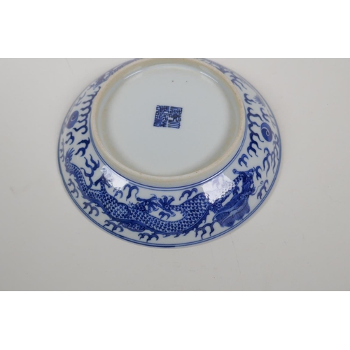 50 - A blue and white porcelain dish decorated with a dragon chasing the flaming pearl, Qianlong seal mar... 