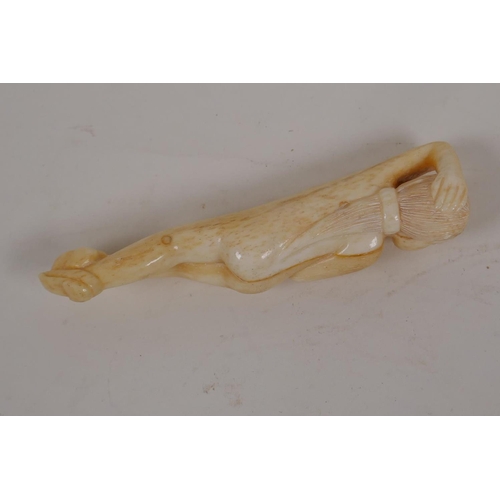 59 - A Japanese bone okimono carved as a female nude, 3½