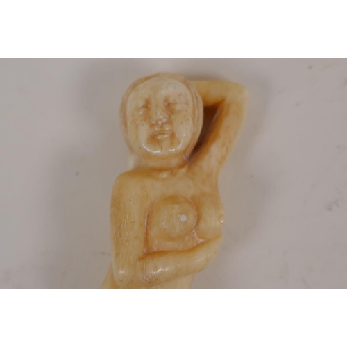 59 - A Japanese bone okimono carved as a female nude, 3½