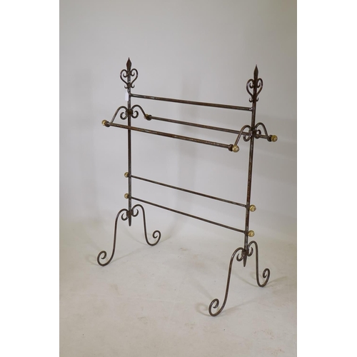 1196 - A Gothic style wrought iron towel rail with brass terminals, 40