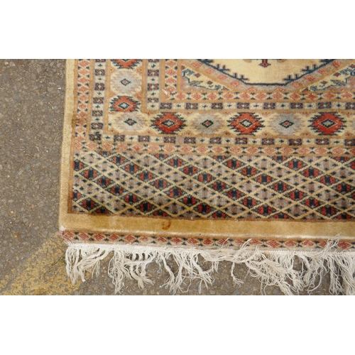 1188 - A gold ground wool Bokhara carpet, signed, 52