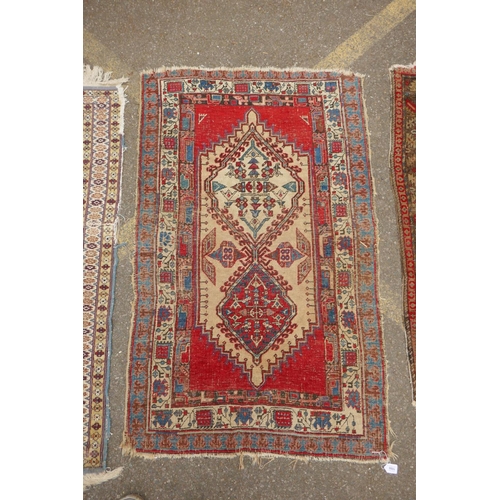 1182 - A Persian blue ground wool rug with geometric medallions and stylised birds design, a red ground Her... 