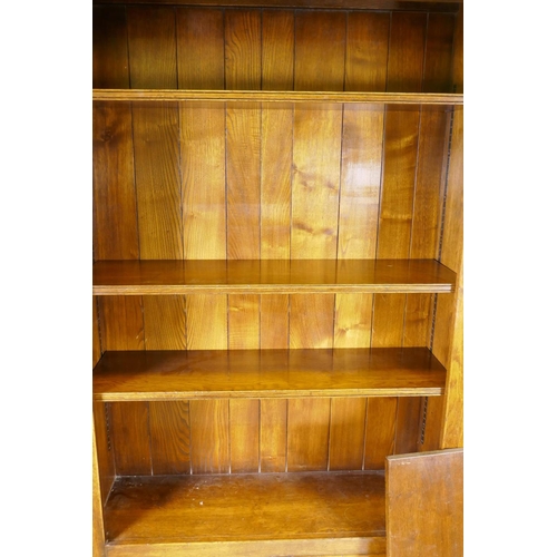 1167 - An oak open bookcase over two cupboard doors, 41½