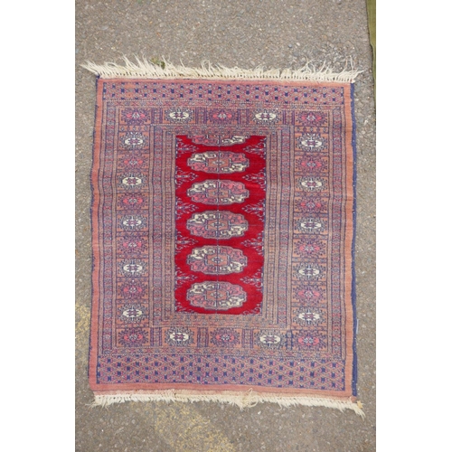 1185 - A terracotta ground wool bokhara prayer rug, and a Persian green ground wool rug with a blue and ora... 