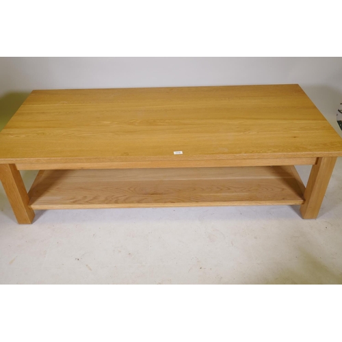 1180 - A solid golden oak two tier coffee table, bears label New Forest Furniture Ltd, 66