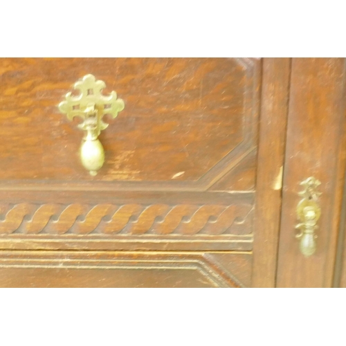 1203 - A 1930s Jacobean style oak buffet, two cupboards with linen fold carved decoration flanking two draw... 