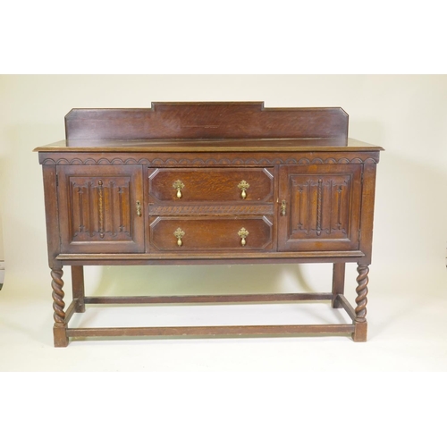 1203 - A 1930s Jacobean style oak buffet, two cupboards with linen fold carved decoration flanking two draw... 