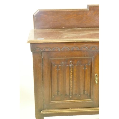 1203 - A 1930s Jacobean style oak buffet, two cupboards with linen fold carved decoration flanking two draw... 