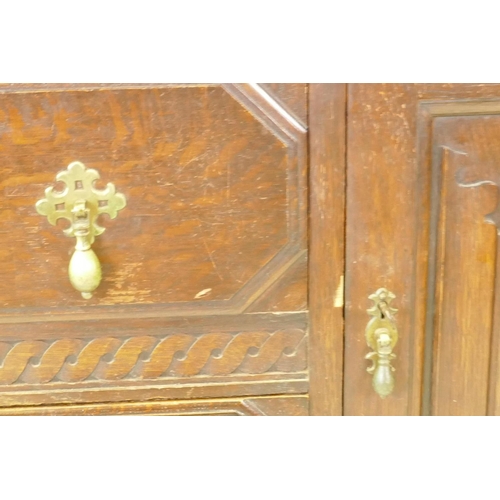 1203 - A 1930s Jacobean style oak buffet, two cupboards with linen fold carved decoration flanking two draw... 