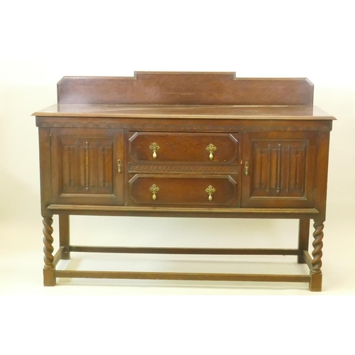 1203 - A 1930s Jacobean style oak buffet, two cupboards with linen fold carved decoration flanking two draw... 