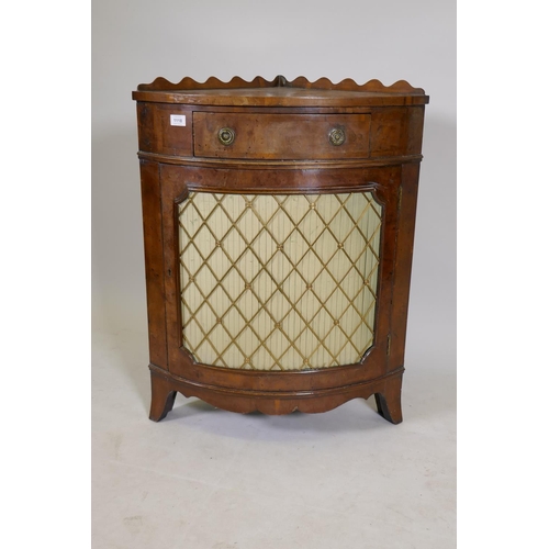 1168 - An early C20th yew wood corner cabinet with a shaped gallery and fringe, raised on swept feet, the d... 